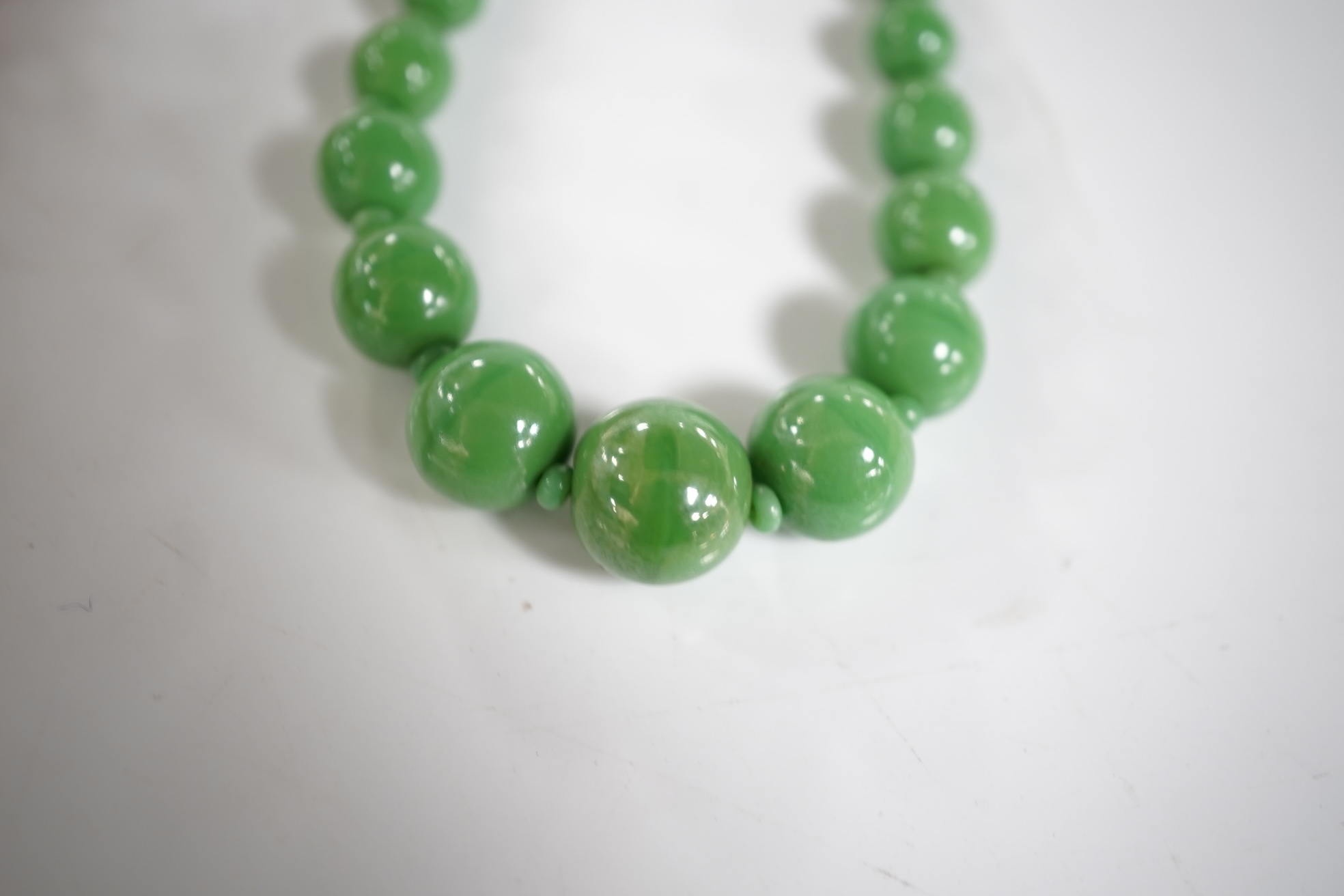 A micromosaic brooch and a group of bead necklaces, comprising: a micromosaic brooch depicting the Forum, length 4.6cm; together with a carnelian bead necklace; a coral branch necklace; and a green glass bead necklace